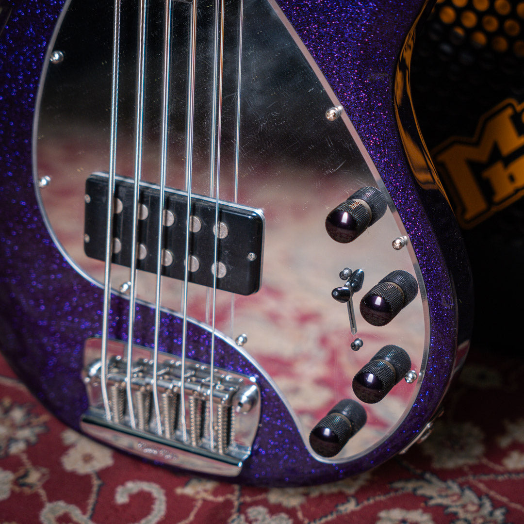 Musicman Stringray 5 Sparkle Purple 1999 - Bajo Eléctrico | Cuerpo • Modelo: Stingray Classic• Madera: Ash• Terminación: Polyurethane Sparkle Brazo • Madera: Maple• Perfil: “C”• Terminación: Satin • Espaciado: 19 mm• Escala: 34” • Nuez: Hueso Diapasón • M