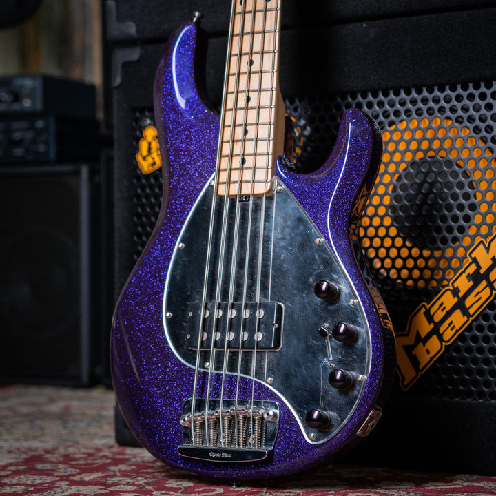 Musicman Stringray 5 Sparkle Purple 1999 - Bajo Eléctrico | Cuerpo • Modelo: Stingray Classic• Madera: Ash• Terminación: Polyurethane Sparkle Brazo • Madera: Maple• Perfil: “C”• Terminación: Satin • Espaciado: 19 mm• Escala: 34” • Nuez: Hueso Diapasón • M