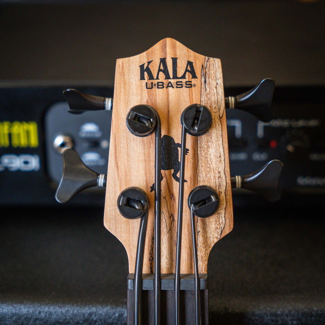 Ubass Kala Sp-Mapl-Fs - Bajo Ukulele | El Ubass Kala SP-MAPL-FS tiene grietas en la madera que se asemejan a garabatos de punta fina que forman líneas negras onduladas y rayas que contrastan maravillosamente con el arce de dos tonos de color más claro. El