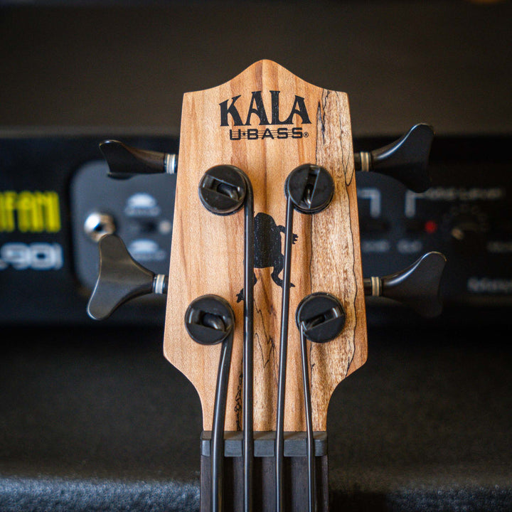 Ubass Kala Sp-Mapl-Fs - Bajo Ukulele | El Ubass Kala SP-MAPL-FS tiene grietas en la madera que se asemejan a garabatos de punta fina que forman líneas negras onduladas y rayas que contrastan maravillosamente con el arce de dos tonos de color más claro. El