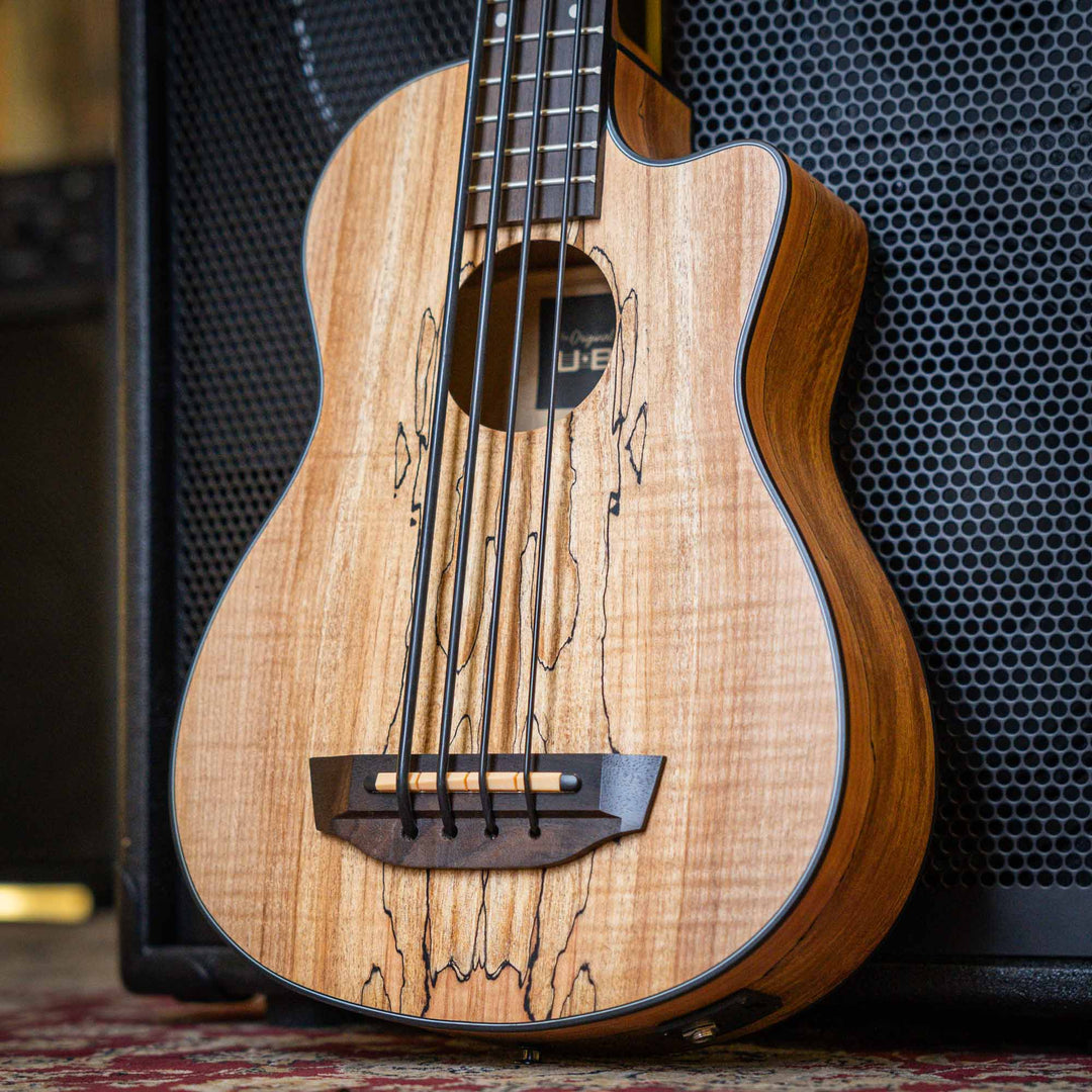 Ubass Kala Sp-Mapl-Fs - Bajo Ukulele | El Ubass Kala SP-MAPL-FS tiene grietas en la madera que se asemejan a garabatos de punta fina que forman líneas negras onduladas y rayas que contrastan maravillosamente con el arce de dos tonos de color más claro. El
