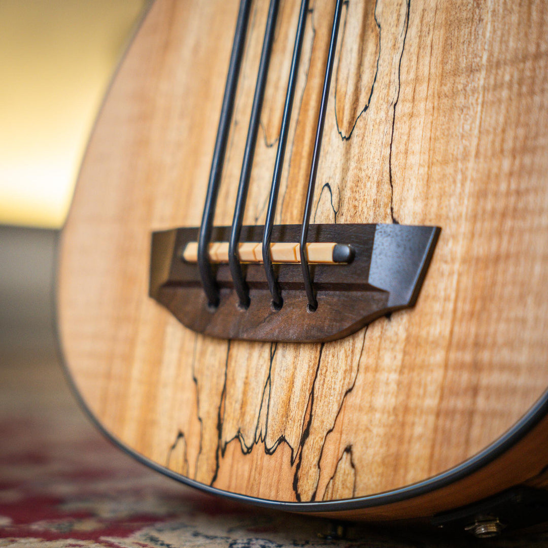 Ubass Kala Sp-Mapl-Fs - Bajo Ukulele | El Ubass Kala SP-MAPL-FS tiene grietas en la madera que se asemejan a garabatos de punta fina que forman líneas negras onduladas y rayas que contrastan maravillosamente con el arce de dos tonos de color más claro. El
