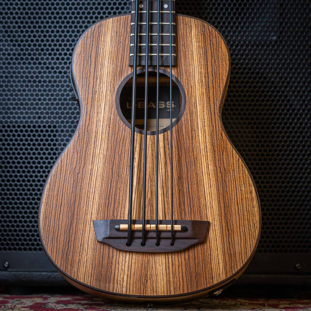 Ubass Kala Zeb-Fs - Bajo Ukulele | El Zebrawood del Ubass Kala Zeb-Fs recibe su nombre y apariencia exótica de las rayas alternas de color canela y marrón oscuro parecidas a una cebra de la veta de la madera. El atractivo Zebrawood ofrece bajos y agudos b