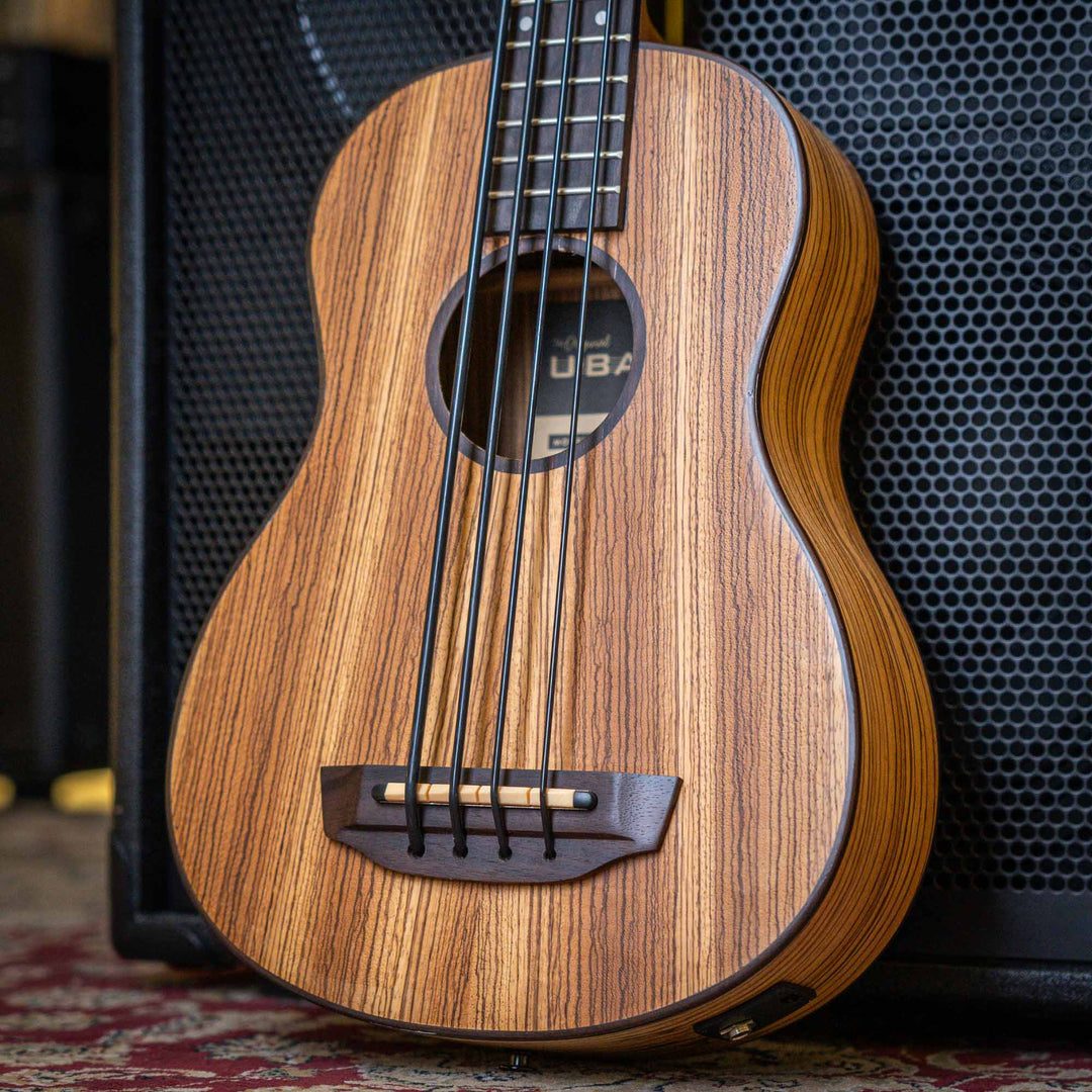 Ubass Kala Zeb-Fs - Bajo Ukulele | El Zebrawood del Ubass Kala Zeb-Fs recibe su nombre y apariencia exótica de las rayas alternas de color canela y marrón oscuro parecidas a una cebra de la veta de la madera. El atractivo Zebrawood ofrece bajos y agudos b