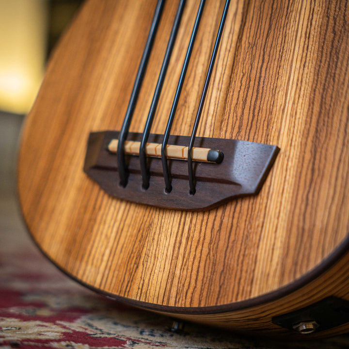 Ubass Kala Zeb-Fs - Bajo Ukulele | El Zebrawood del Ubass Kala Zeb-Fs recibe su nombre y apariencia exótica de las rayas alternas de color canela y marrón oscuro parecidas a una cebra de la veta de la madera. El atractivo Zebrawood ofrece bajos y agudos b
