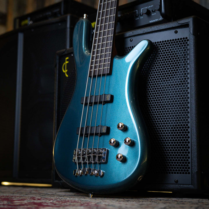 Warwick Streamer LX5 Emerald Green 2016 - Bajo Eléctrico | Cuerpo • Modelo: Streamer• Madera: Mahogany• Terminación: Emerald Green Brazo • Madera: Ovangkol• Perfil: “C”• Terminación: Satin • Espaciado: 17.5 mm• Escala: 34” • Nuez: Just-A-Nut II 45 mm Diap