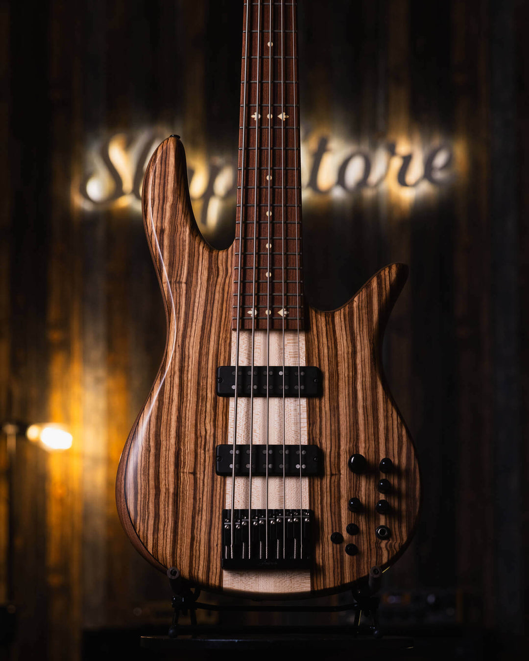Fodera Monarch 5 Elite 38th Anniversary Zebrawood 2022 - Bajo Eléctrico | Cuerpo • Modelo: Monarch• Madera: Walnut with Alder Tone-Block (Chambered) • Top: Zebrawood• Terminación: Matte Brazo • Madera: 3 Piezas de Hard-Rock Maple• Perfil: Regular• Termina