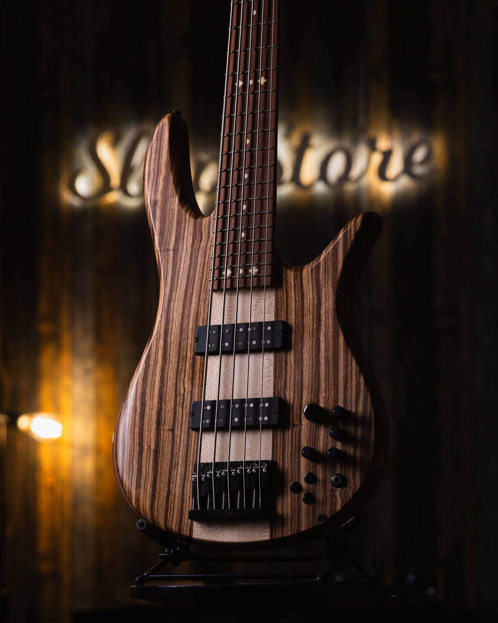 Fodera Monarch 5 Elite 38th Anniversary Zebrawood 2022 - Bajo Eléctrico | Cuerpo • Modelo: Monarch• Madera: Walnut with Alder Tone-Block (Chambered) • Top: Zebrawood• Terminación: Matte Brazo • Madera: 3 Piezas de Hard-Rock Maple• Perfil: Regular• Termina