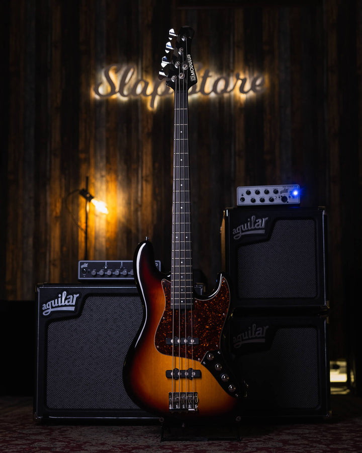 Modulus VJ4 Sunburst 2000 - Bajo Eléctrico | Ubicada en el corazón de la próspera escena musical del Área de la Bahía de San Francisco, Modulus Graphite comenzó a fabricar instrumentos excepcionales hechos a mano en 1978. La especialidad de Modulus es uti