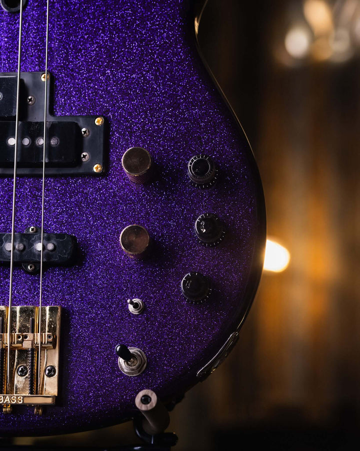 Yamaha BB1100s Purple Sparkle '85 - Bajo Eléctrico | Cuerpo • Modelo: BB1100s• Madera: Alder • Terminación: Purple Sparkle, Gloss Brazo • Madera: Maple• Terminación: Gloss• Perfil: "C"• Espaciado: 18mm• Escala: 34"• Nuez: Bronze Diapasón • Madera: Ebony•