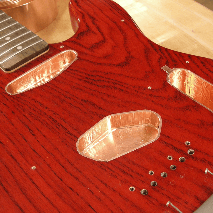 Blindaje & Apantallado | El blindaje de las cavidades donde se aloja la electrónicas consiste en dar tres manos con pintura conductiva especializada para luego apantallar con láminas de cobre adhesivo, lo cual mantiene a tu instrumento libre de ruidos y s