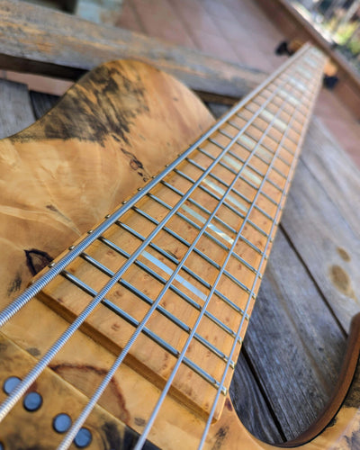 Fodera Imperial MG 5 Elite Buckeye Burl 2008 - Bajo Eléctrico | Cuerpo • Modelo: Imperial MG• Madera: Walnut• Top: Buckeye Burl • Terminación: Satin Brazo • Madera: 3-Pieces Maple• Perfil: Regular• Terminación: Satin • Espaciado: 19 mm• Escala: 34” • Nuez