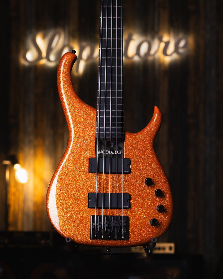 Modulus Quantum 5 Orange Sparkle 2001 - Bajo Eléctrico | Ubicada en el corazón de la próspera escena musical del Área de la Bahía de San Francisco, Modulus Graphite comenzó a fabricar instrumentos excepcionales hechos a mano en 1978. La especialidad de Mo