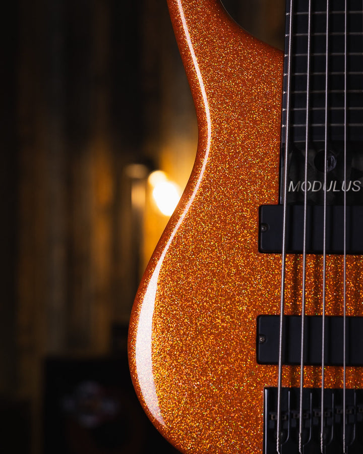 Modulus Quantum 5 Orange Sparkle 2001 - Bajo Eléctrico | Ubicada en el corazón de la próspera escena musical del Área de la Bahía de San Francisco, Modulus Graphite comenzó a fabricar instrumentos excepcionales hechos a mano en 1978. La especialidad de Mo